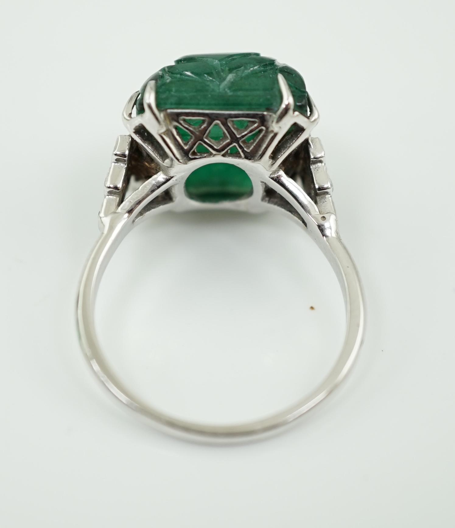 A French 1920's style platinum and single stone emerald set dress ring, with twelve stone millegrain set diamond stepped shoulders